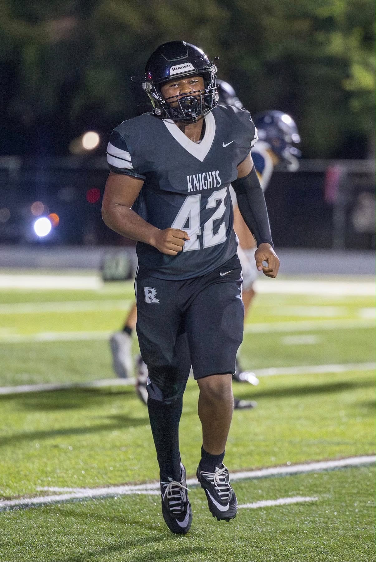 Deshaun McDonald running on the football field in his Knights uniform and helmet